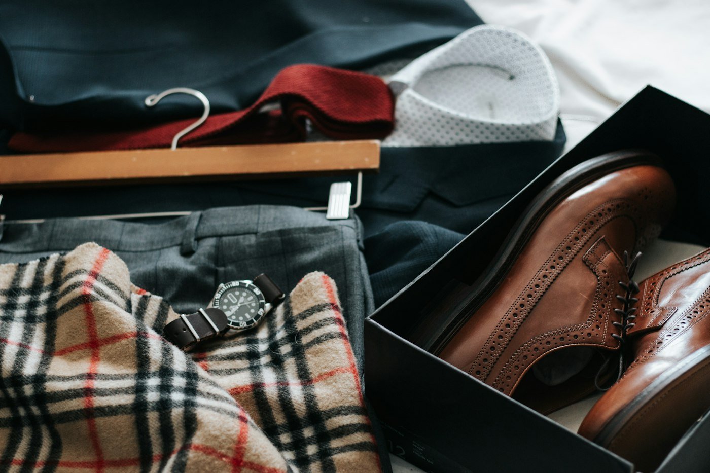 Tie, shirt, trousers, and dress shoes arranged as a coordinated outfit.